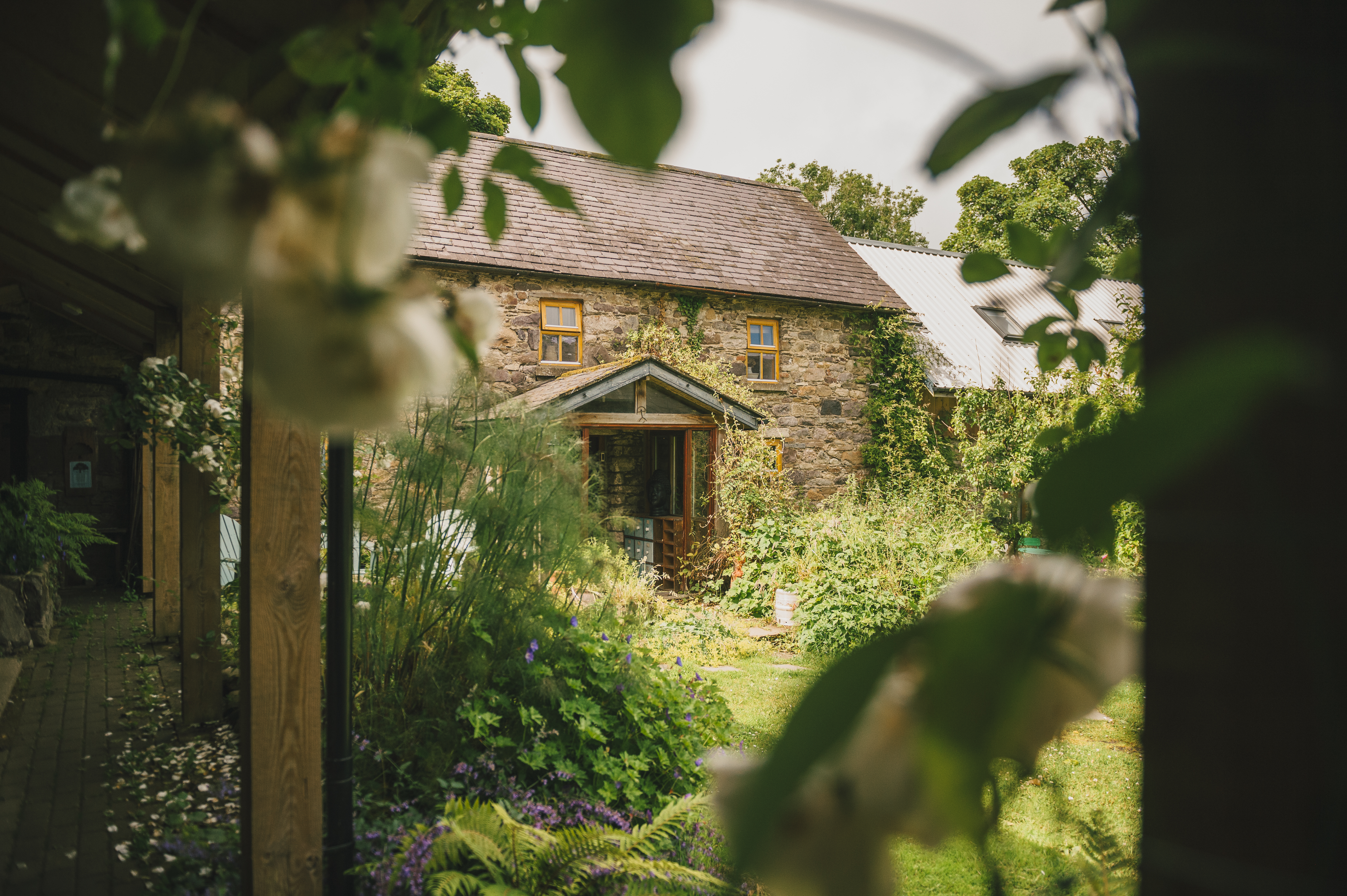 Casa de retiro em pedra no interior da Irlanda, cercada de jardim e roseiras